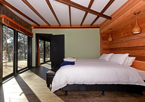 South BrunyTaylors Bay Cottage的一间带一张大床的卧室,位于带窗户的房间内