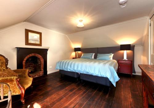 South BrunyVentnor Guest House的一间卧室设有一张大床和一个壁炉