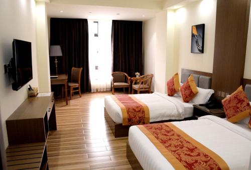 碧瑶Hotel Tugos的酒店客房设有两张床和电视。