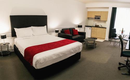 墨尔本Melbourne Kew Central Apartments Official的酒店客房设有一张大床和一个厨房。