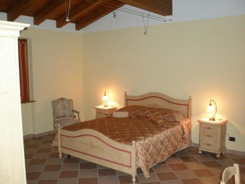 Povegliano Veronese伊尔法吉奥住宿加早餐旅馆的一间卧室配有一张带2个床头柜和2盏灯的床。
