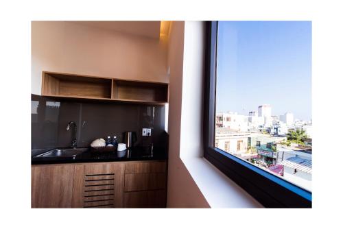 岘港AHA Thang Bom Apartment Da Nang的厨房设有窗户,享有城市美景