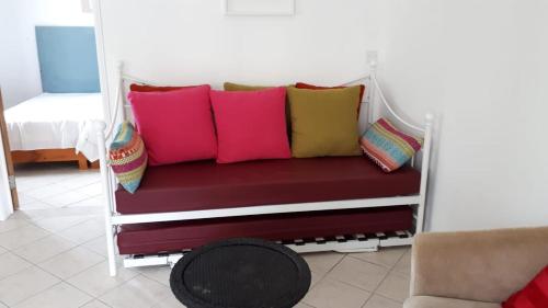 马埃堡Sacha Tourist Residence 2的一张长凳,上面有色彩缤纷的枕头