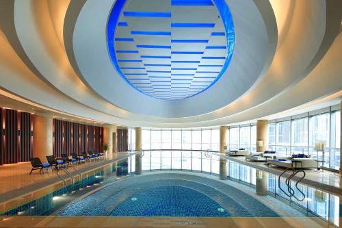 无锡无锡太湖皇冠假日酒店的一座大型游泳池,位于一座拥有大型天花板的建筑内