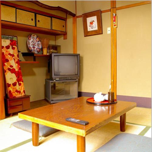 京都达亚旅馆的客厅配有咖啡桌和电视