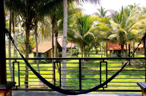 KalakArrys Watukarung Surfcamp的棕榈树围栏前的吊床