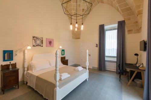 曼杜里亚Vinilia Wine Resort的一间卧室配有一张床、一张桌子和一个窗户。