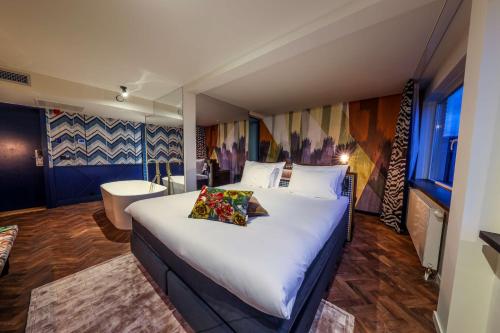 阿纳姆Hotel Haarhuis的一间带大床的卧室和一间浴室