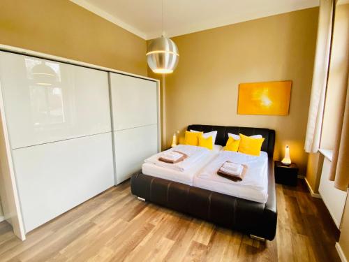 黑灵斯多夫Villa Anna - Vis à vis的一间卧室配有一张带黄色枕头的床