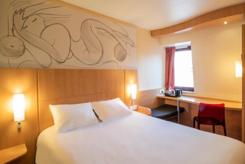 勒芒宜必思勒芒中心酒店的配有一张床、一张书桌和一扇窗户的酒店客房