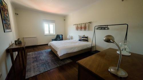 波亚里什新镇Quinta dos Lameiros的一间卧室配有一张床和一张带台灯的书桌