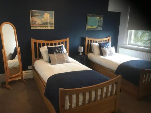 泰晤士河畔沃尔顿The Weir Hotel的卧室设有两张床铺和蓝色的墙壁