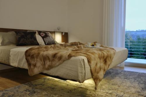 Belforte del ChientiChiaroscuro的卧室里一张带人造毛皮毯子的床