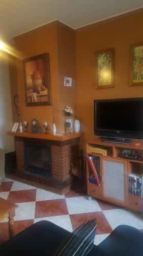卡萨韦梅哈El Rengue的客厅设有壁炉和平面电视。