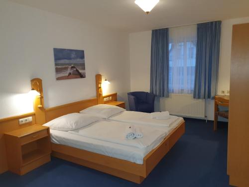 BroderstorfHotel-Pension Pastow Garni的一间卧室配有一张大床和两条毛巾