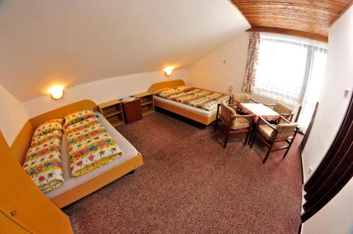 弗尔赫拉比Pension 444 - Ski Resort Herlikovice and Bubakov的一间设有两张床和一张桌子及椅子的房间