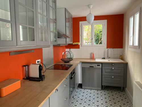 维希La Villégiature的厨房设有橙色墙壁和木制台面