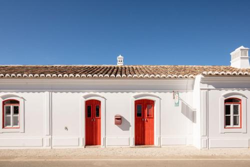 AlvisquerHospedaria的白色的建筑,有红色的门窗