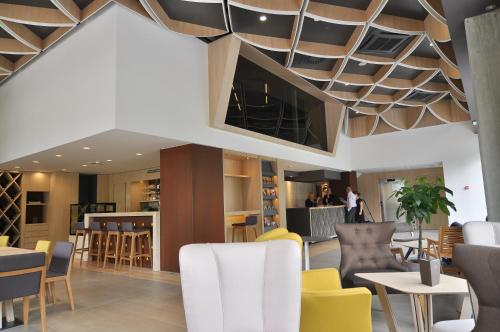 卢布尔雅那诺克斯酒店的餐厅拥有格子天花板和桌椅