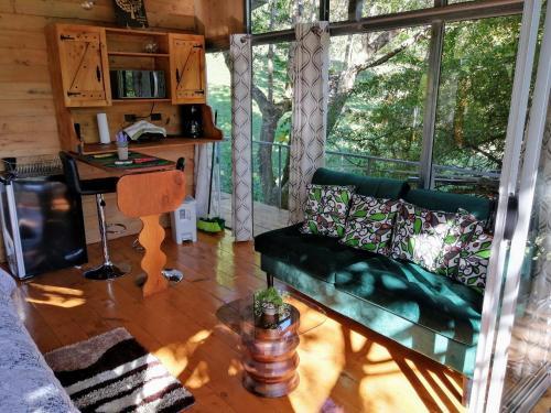San IsidroCabaña treehouse Mountain View的客厅配有绿色沙发和桌子