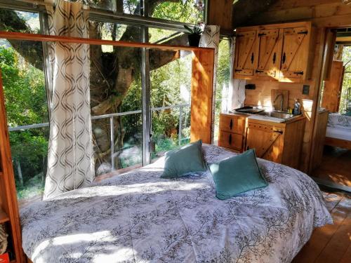 San IsidroCabaña treehouse Mountain View的卧室在窗户前配有一张床