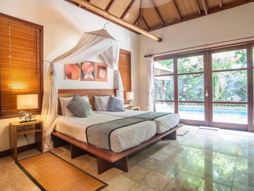 金巴兰芒果树别墅的一间卧室配有一张带天蓬的床