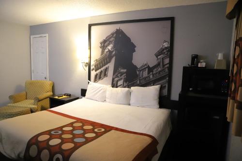 桑兹顿速8里士满机场酒店的酒店客房设有一张床,墙上挂着一张照片