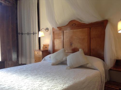 AlmedíjarCasa Rural Pico Espadan的卧室配有白色的床和木制床头板