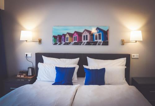梅尔布施奥斯塔切火酒店及餐厅的一间卧室配有一张带蓝色和白色枕头的床