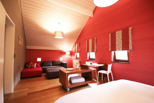 斯普里蒙L'Impasse de Lincé的红色的房间,配有沙发和桌子
