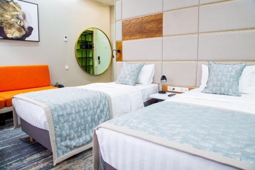 阿拉木图Kazzhol Park Hotel Almaty的酒店客房,设有两张床和镜子