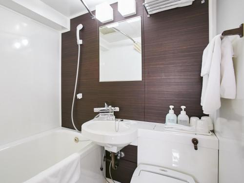 泉佐野康库太阳丰酒店的一间带水槽、卫生间和镜子的浴室