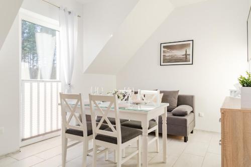 乌斯特卡Nadmorska Przystan - Apartamenty caloroczne的白色的用餐室配有白色的桌椅