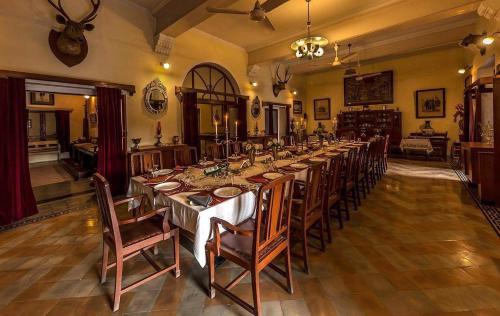 KarauliBhanwar Vilas Palace的大型用餐室配有长桌和椅子