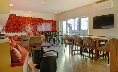 波尔图斯波特家庭套房酒店的餐厅设有桌椅和大窗户。