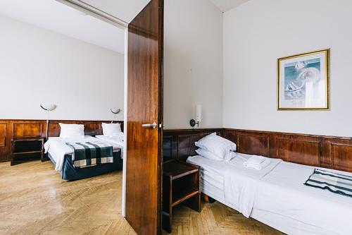 皮耶塔尔萨里Comfort Guesthouse的一间设有两张床的房间和一扇通往卧室的门