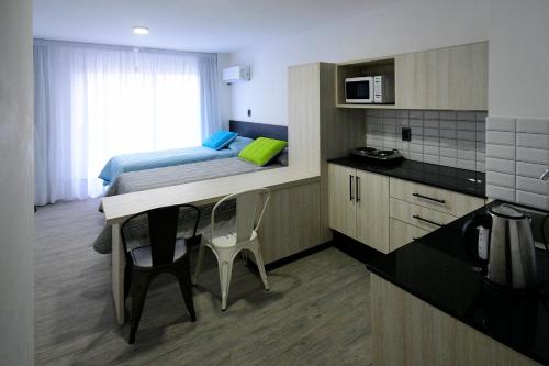 蒙得维的亚Quijano Hotel - Aparts & Suites的小房间设有床和厨房