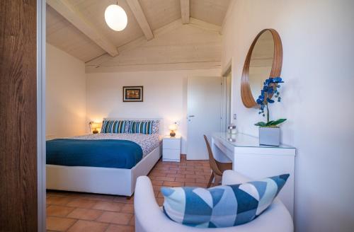乌尔比诺Country House Ca' Brunello的一间卧室配有一张床、一把椅子和镜子