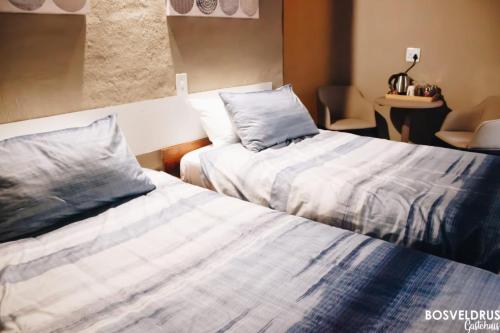 法尔瓦特Bosveldrus Gastehuis的两张睡床彼此相邻,位于一个房间里