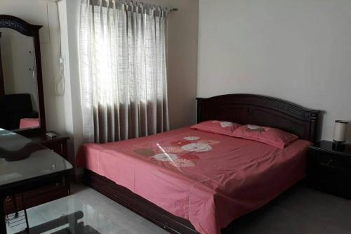 达卡Impressa on Shah的一间卧室配有一张带粉色床单的床和一扇窗户。