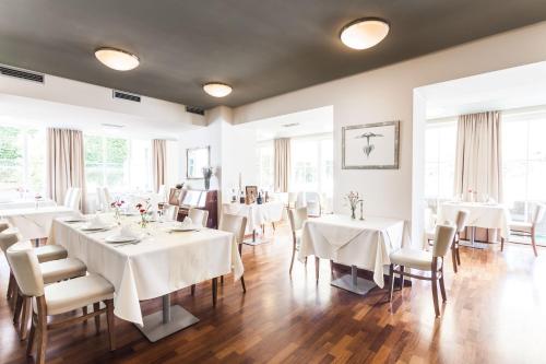 鲁哈科维斯拉敦酒店的一间设有白色桌椅和窗户的用餐室