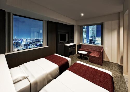 名古屋Sanco Inn Grande Nagoya -HOTEL & SPA-的酒店客房设有两张床和窗户。