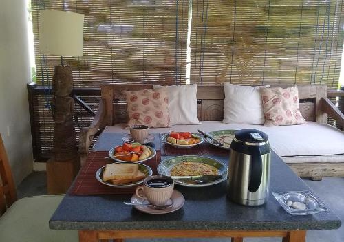 毛梅雷Waiara Village Guesthouse的沙发上带食物盘的早餐桌