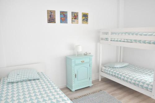 卡斯卡伊斯Cascais Family & Friends的客房设有两张双层床和蓝色橱柜。