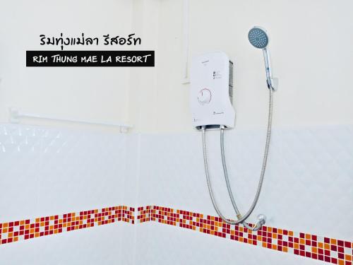 信武里府ริมทุ่งแม่ลา รีสอร์ท Rim-Thung-Mae-La-Resort的浴室设有淋浴,铺有红白色瓷砖