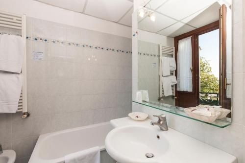 威尼斯丽都Hotel Riviera Venezia Lido的白色的浴室设有水槽和镜子