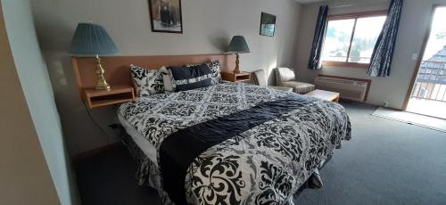 戈尔登玛丽汽车旅馆的一间卧室配有一张带两盏灯的黑白床。