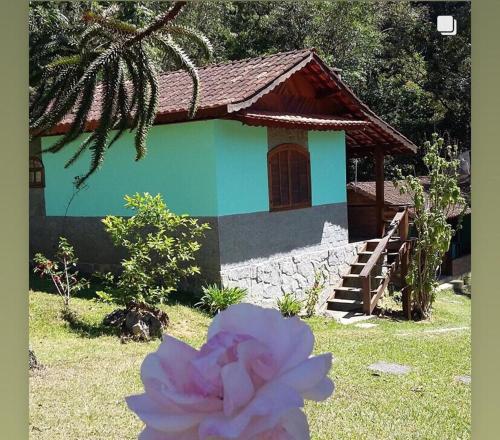 维奥康德马奥Chalés Aguá Cristalina的前面有粉红色花的房子