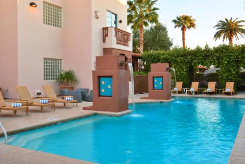 土桑Lodge On The Desert的一个带椅子的游泳池和一间酒店