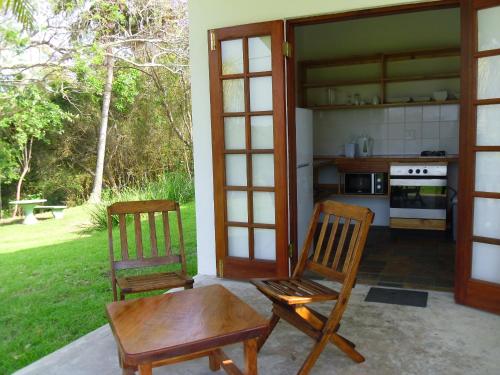 绍斯布鲁姆Bellevue Guest Lodge的一个带两把椅子和一张桌子的庭院和一间厨房